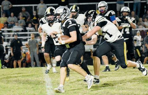 Luke Lovin evades the pursuit of Tuscola defenders while gaining positive yardage in Friday's season opener. Lovin will be Robbinsville's quarterback for the 2025 season. Photos by Bella Eddings/The Graham Star