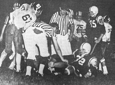 With his chin strap loosened, Larry Sawyer struggles to his feet after earning a first down in Robbinsville's season-opening victory over Andrews on Sept. 4, 1970.
