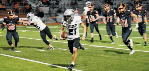 Robbinsville's Eli Lambert leaves an ambush of Tigers in his wake Friday at Rosman. Lambert had a career night, reeling in two scoring receptions and also returning a punt for a touchdown in the Black Knights' rout. Photo by Kevin Hensley/sports@grahamstar.com