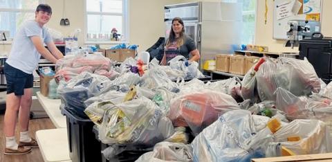 Nathanael Shope (left) and Terra Fouts stand with just a sample of the food collected to provide a Thanksgiving meal at Grace Place, A Community Table.