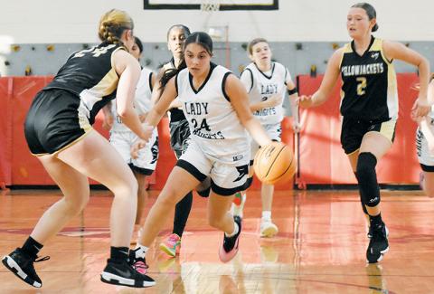 Robbinsville's McKynlee Adams splits the defense of Hayesville's Ayden Margo (24) and Kaelyn Cook (2) during Monday's season opener. Photo by Kevin Hensley/sports@grahamstar.com
