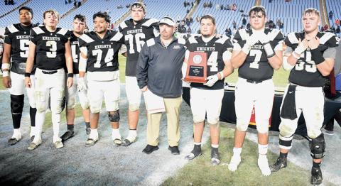 Members of the Robbinsville Black Knights fight back tears of disappointment Dec. 11, after being handed the 1A state runner-up trophy following a 9-8 loss in the championship game to Wilson Preparatory Academy. From left are Kyzik Teesateskie, Luke Lovin, Ryelon Waldroup, John Dominguez, Dane Daniels, head coach Lucas Ford, Kellen Ensley, Isiac Collins and Kasen Buchanan. Photo by Kevin Hensley/sports@grahamstar.com