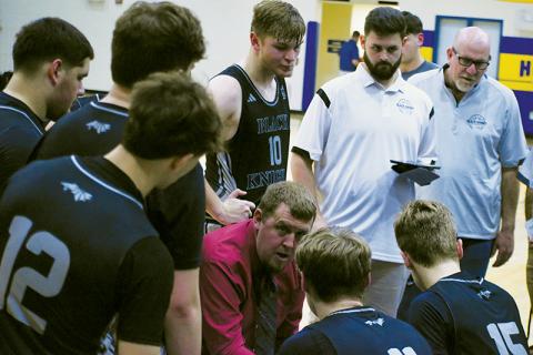 Black Knights head coach Jake Beasley (center, kneeling) talks strategy with his team, shortly before the second half of Jan. 8's road game against Highlands gets underway. Photo by Kevin Hensley/sports@grahamstar.com