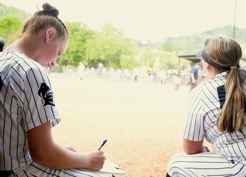 Robbinsville freshman Ella Nelms (left) has not been content filling out a pitch-count chart over the last two weeks – but it's all the ace of the Lady Knights pitching staff is capable of, after being sidelined with an injury. Nelms is expected to return to action during Friday's season finale against Murphy. Photo by Kevin Hensley/sports@grahamstar.com