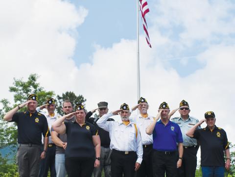 Veterans stand in front of the massive flag that was raised for the first time Memorial Day off Old Tallulah Road. All names are listed from left in each row. Front row: Amanda Gyongyos, Rudy Leopold, Barry Watkins and Billy Cable. Second row: Travis Brooks, Caleb Stiles, Joseph Vasquez, Hubert Merchant and Buddy Adams. Standing in back is Harold Phillips. Photo by Lexie Anderson/The Graham Star
