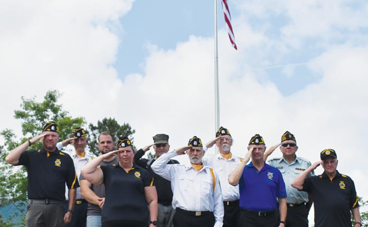 Veterans stand in front of the massive flag that was raised for the first time Memorial Day off Old Tallulah Road. All names are listed from left in each row. Front row: Amanda Gyongyos, Rudy Leopold, Barry Watkins and Billy Cable. Second row: Travis Brooks, Caleb Stiles, Joseph Vasquez, Hubert Merchant and Buddy Adams. Standing in back is Harold Phillips. Photo by Lexie Anderson/The Graham Star