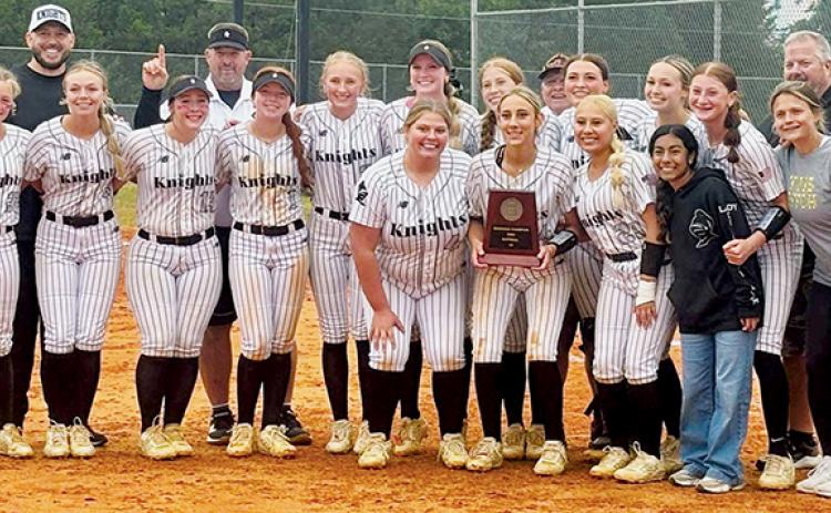 The Robbinsville Lady Knights gather around the 2026 1A Western Regional championship plaque, minutes after clinching the program's first-ever state-title appearance. Photo courtesy of Sasha Watty/Contributing Photographer