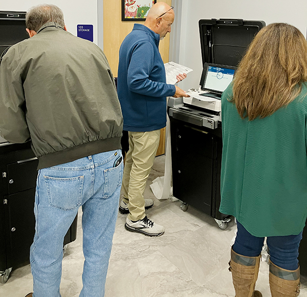 Graham County Board of Elections members Lowell Crisp (left) and Beefy Rogers (center) join deputy director Tasha Holder in trying out the new Printelect machines during Dec. 7’s mock election. The upgraded equipment will be available to local voters next year. Photo courtesy of Graham County Board of Elections
