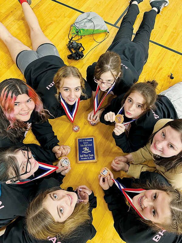 The Robbinsville Lady Knights gather around their second-place plaque from the Enka Jet Invitational on Nov. 22. Clockwise from top are Alexis El-Khouri, Anna Norris, Andrea Sheeks, Pacey Bradshaw, Campbell Brooks, Nora Thomas, Koda Stinson and Abree Teesateskie. Photo courtesy of Sarah Orr/Contributing Photographer