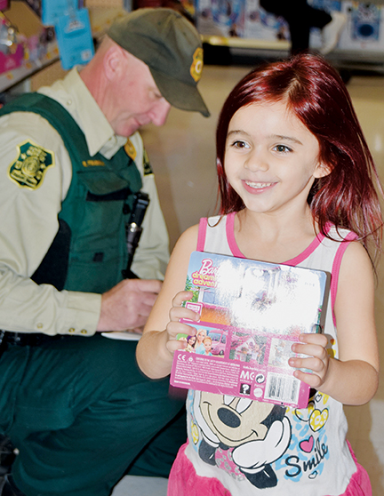 Gracelyn Hoyle could not contain her excitement after getting a Barbie playset during last year’s “Shop with a Cop” event at the Sylva Walmart. The holiday tradition returns for its third installment next month. Photo by Art Miller/amiller@grahamstar.com