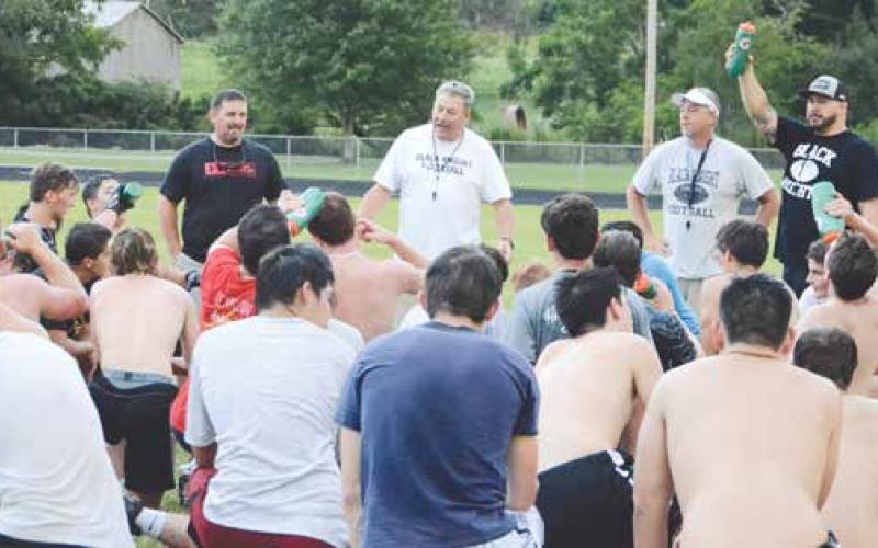 Robbinsville head football coach Dee Walsh addresses his players at the conclusion of the first 2019 practice August 1. A member of the 1973 and 1974 Black Knights state championship teams, Walsh is well-versed in what it takes to make Graham County players successful.