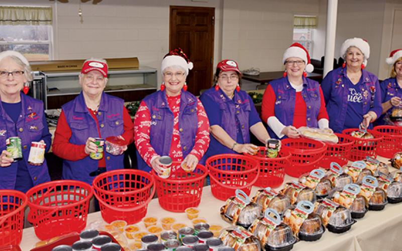Susan Lyons, Bonnie Jeroslow, Cyndi Postell, Angie Colvin, Sandy Graves, Joyce Mitchell and Deborah Cheney (from left) stand prepared for assembly work during the Red Hat Lady Dragons’ annual Gifts from the Heart event Tuesday, Dec. 17. Photo by Art Miller/amiller@grahamstar.com