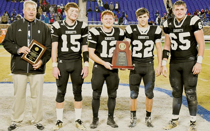 Filled with emotion, Robbinsville head coach Dee Walsh joins Clayson Lane, Kamron McGuire, Rylee Anderson and Grady Garland (from left) in accepting the 1A state championship trophy after Saturday’s win over the Northampton County Jaguars. Photo by Kevin Hensley/editor@grahamstar.com