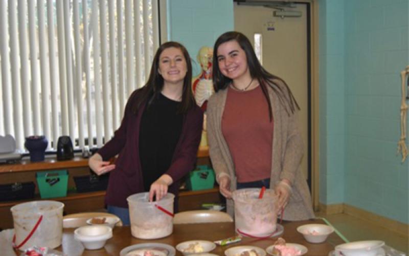 Robbinsville High School HOSA President Emma Nichols (left) and Addison Moody serve ice cream to high school students for reaching the service project goal.