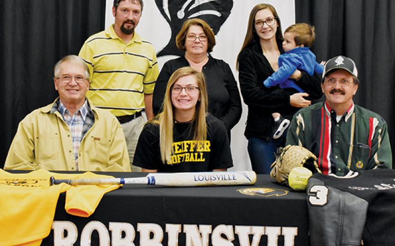 Lady Knights senior Gracye Burchfield (seated, center) signed with Pfeiffer University on Dec. 4. Seated with Burchfield are Larry Icenhower (left) and Gary Icenhower. Standing in back (from left) are Brent Icenhower, Barbara Icenhower, Hannah Lewis and Jordan Lewis. Photo by Kevin Hensley/editor@grahamstar.com