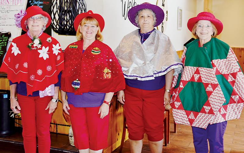 Susan Lyons, Deborah Cheney, Joyce Mitchell and Glenda Raulerson (from left) participated in the “Tree Skirts” contest, one of several fun-filled festivities the Red Hat Ladies enjoyed at Saturday’s “Christmas in July.” Photo by Art Miller/amiller@grahamstar.com