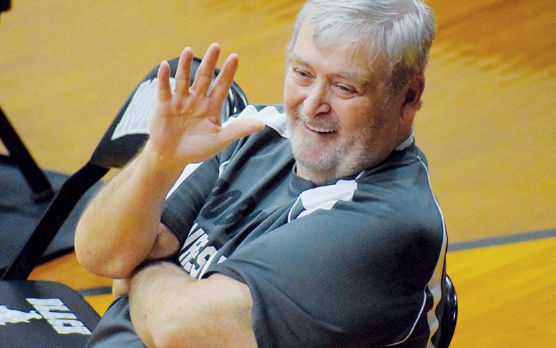 Right at home while sitting at the edge of the mat, George Oliver waves to spectators before the start of a Robbinsville match. The co-founder of the Black Knights’ wrestling program passed away Aug. 5. Photos by Jenny Millsaps/The Graham Star