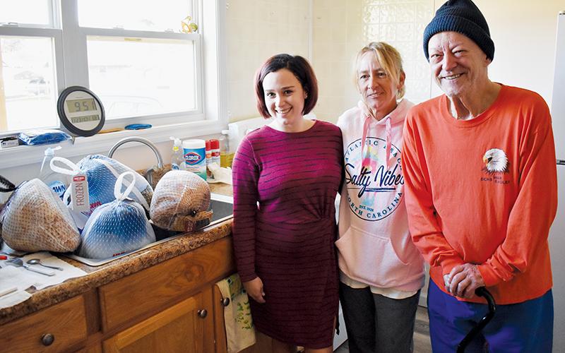 Brandi Oocumma, Tracy Bradley and Bob Culler (from left) with all the meat the family will serve for the second community Thanksgiving it has hosted on Snider Circle. Photo by Charlie Benton/news@grahamstar.com