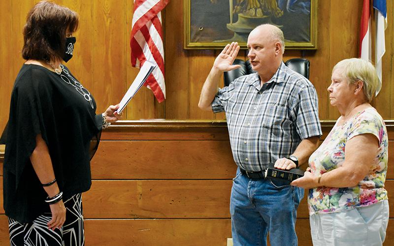 Graham County Clerk of Court Tammy Holloway (left) swears in Jerry Crisp as the new Graham County Sheriff on July 28. Holding the Bible is Jerry’s aunt, Janet Crisp Lequire. Photo by Kevin Hensley/editor@grahamstar.com