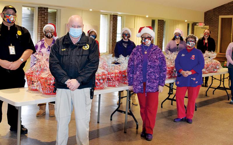 The Red Hat Lady Dragons teamed up with the Graham County Sheriff’s Office on Dec. 17, to deliver Christmas packages to those in need. Standing in front (from left) are Graham County Sheriff Jerry Crisp, Deborah Cheney, Marlene Carver and Peggy Denton. Standing in back (from left) are Vincent Wesley, Cyndi Postell, Glenda Raulerson, Susan Lyons, Amy Docker and Dusti Cox.
