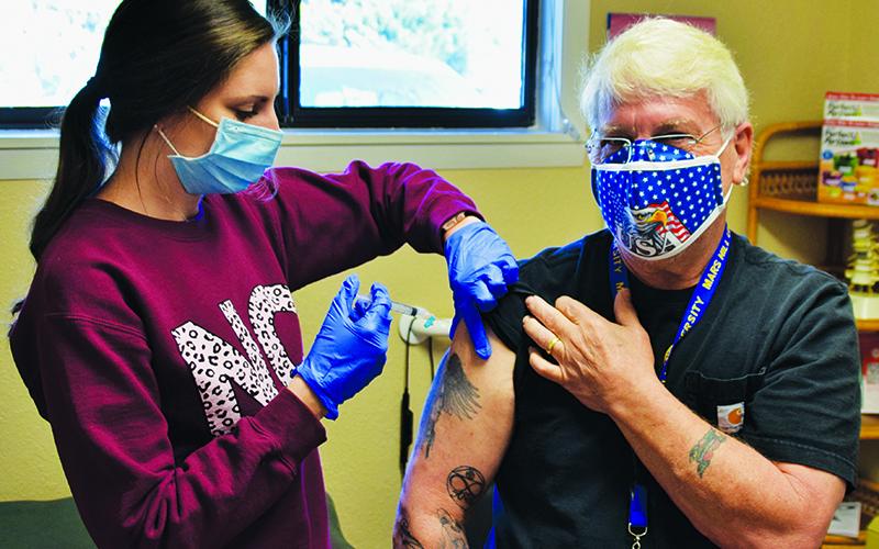 Graham Star photographer Art Miller began his COVID-19 vaccination process Friday. He received his first shot at Tallulah Health Clinic. Administering the shot is Hannah Anderson. Photo courtesy of Cory Franklin.