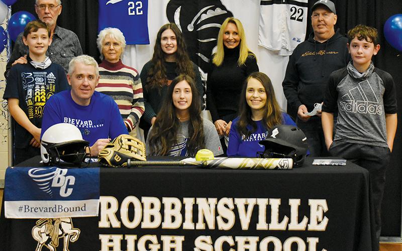 Robbinsville senior Gabby Hooper (center, seated) signed her letter of intent to play college softball with Brevard on Monday. Sitting with Hooper are parents Gabe and Crystal Hooper. Standing in back (from left) are brother Loxston Hooper, grandparents Clayton and Lana Hooper, sister Delaney Hooper, grandparents Patricia and Donald Cable, and brother Lleyton Hooper. Photo by Kevin Hensley/editor@grahamstar.com