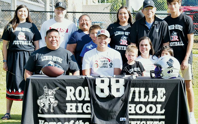 Rossi Wachacha (seated, center) signed his letter of intent to play college football at Lenoir-Rhyne University on June 30. Front row (from left) are father Jeremy Wachacha, Rossi, brother Jace Smith, mother Melissa Smith and sister Jaxtyn Bark. Standing in back (from left) are Rossi' girlfriend Tishara Sneed, friend Court Carpenter, aunt Jennifer Wachacha, cousin Cannon Gross, aunt Paige Gross, grandfather Wayne Wachacha and cousin Dasan Gross. Photo by Kevin Hensley/sports@grahamstar.com