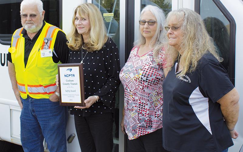 Graham County Transit lead driver Terry Crawford, director Juanita Colvard, assistant director Tracy Jenkins and dispatcher/scheduler Donna Hill (from left) pose with the safety award the system received from the N.C. Public Transit Association. Photo by Charlie Benton/news@grahamstar.com