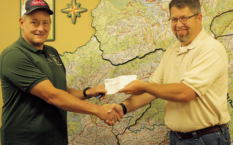 Graham County Rescue Squad Commander Jeff Millsaps (left) accepts a $12,000 donation to the rescue squad from Miatas at the Gap organizer Josh Hankins on Saturday. The annual event alternates donations between the Graham County and Blount County, Tenn. rescue squads. Photo by Charlie Benton/news@grahamstar.com