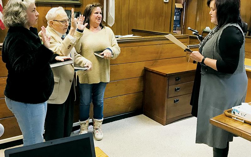 Graham County Clerk of Court Tammy Holloway (right) swears in the new Town of Lake Santeetlah councilmembers Tuesday afternoon (from left): Tina Emerson, Ralph Mitchell and Connie Gross. Recent appeals at both the local and state level have  attempted to dispute the legitimacy of Emerson and Gross’ residency, but both challenges have been dismissed. Photo by Kevin Hensley/editor@grahamstar.com