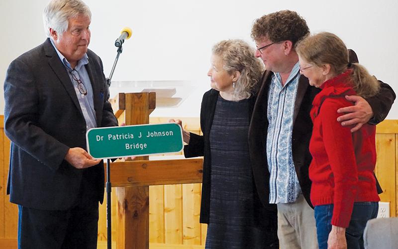Dr. Patricia Johnson (center) receives a replica of a bridge sign from board member Dirk Cody of the N.C. Board of Transportation (left) at a reception in her honor at Cedar Cliff Church on West Buffalo Road on Saturday. Right of her are her nephew Jeremy Sims and her sister Sarah Johnson Sims. Photos by Randy Foster/news@grahamstar.com