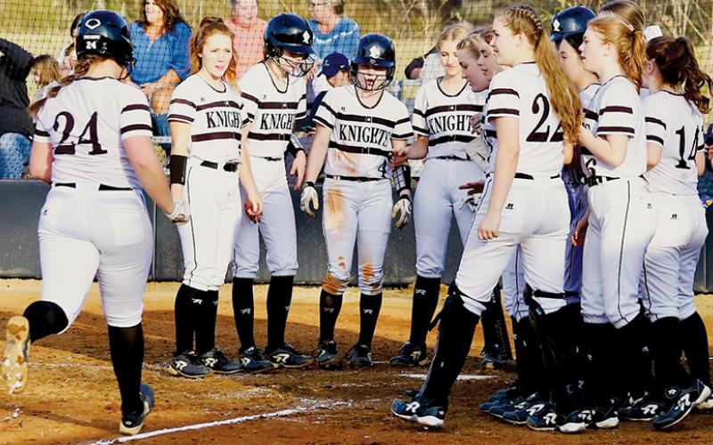 The Robbinsville Lady Knights wait to greet Ivy Odom at home plate, after the senior first baseman slugged one of her two home runs over the fence in Friday’s victory against T.C. Roberson. Photo by Miranda Buchanan/Robbinsville High School Yearbook