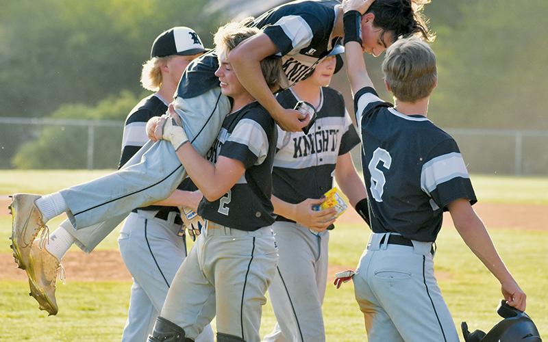As Cole Patterson hoists Christian Phillips in the air Monday, Graylen Orr (right) walks by to congratulate Phillips on his extra-inning, walk-off single against Andrews on Monday. Photo by Kevin Hensley/sports@grahamstar.com