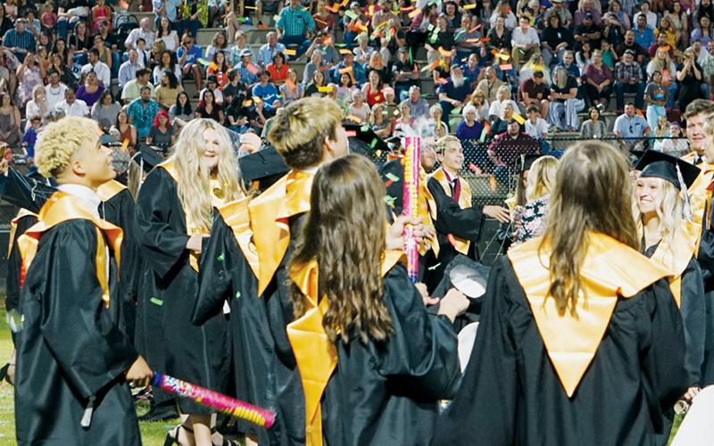 Jayden Nowell (left) and other seniors watch confetti peak and descend during  Friday’s commencement at Modeal Walsh Memorial (Big Oaks) Stadium. Robbinsville High School graduated 86 seniors at the ceremony. Photo by Randy Foster/news@grahamstar.com