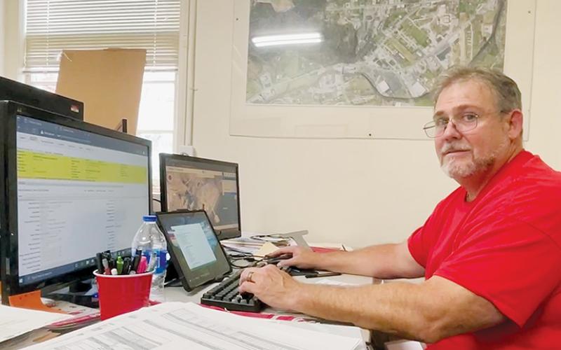 Chris Ferriss reviews revaluation data at his temporary desk at the Graham County Tax Assessor’s office in Robbinsville on Aug. 25. Ferriss is a real estate appraiser and tax consultant hired by the county to assist in its 2023 revaluation. Photo courtesy of Randy Foster/news@grahamstar.com