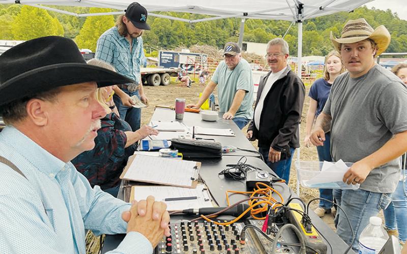 Chase Lancaster, organizer of the Lost in the Mountains Bulls and Barrels Rodeo in Robbinsville, discusses plans with event announcer Bill Hankins of Mississippi (lower left).