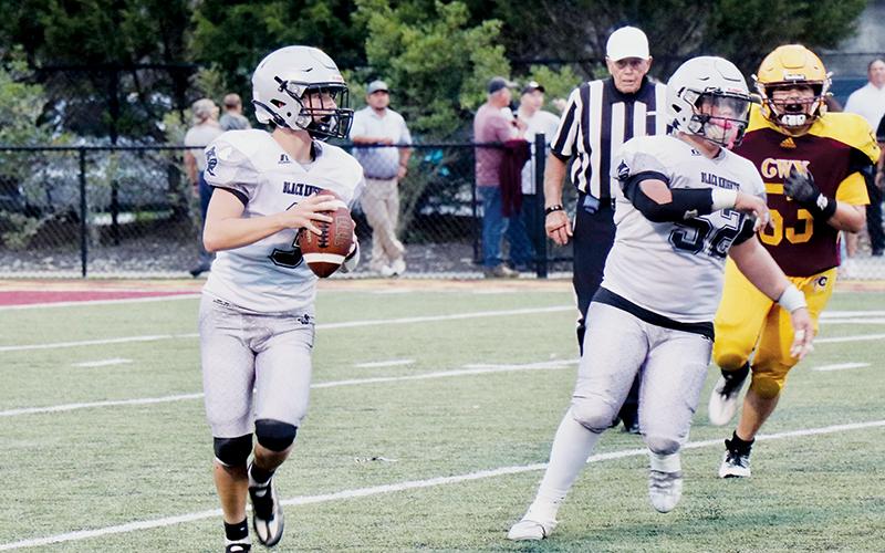 With Kellen Ensley (52) running interference, JV Black Knights quarterback Luke Lovin rolls out for a pass Sept. 8 at Cherokee. Photo courtesy of Haden Key/Robbinsville High School Yearbook