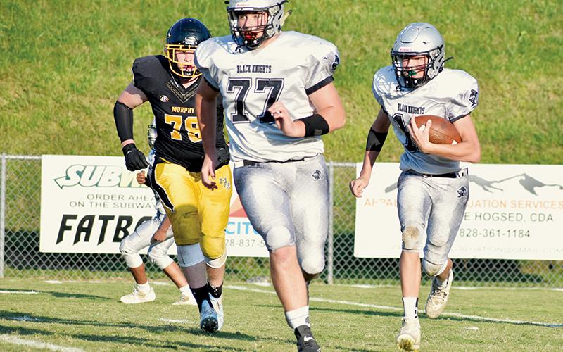 With Murphy’s Jude Pinkerton (78) in pursuit – and Robbinsville’s Owen Blevins (77) scanning the field for any signs of disruption – JV Black Knight Tillman Adams works his way upfield Sept. 15 at Murphy. Photo by Kevin Hensley/sports@grahamstar.com
