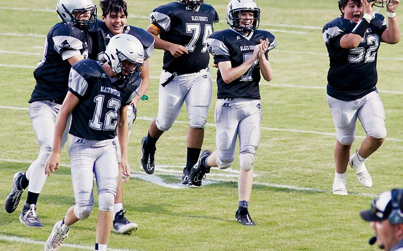 Members of the JV Black Knights – Tillman Adams (12), Kasen Buchanan, Isiac Collins, John Dominguez-Romero (74), Matthew Phillips (7) and Kellen Ensley (52) – were all smiles while jogging off the field after Collins connected on a rare JV point-after during Robbinsville’s 59-6 romping of Andrews on Sept. 22. Photo by Miranda Buchanan/Robbinsville High School Yearbook