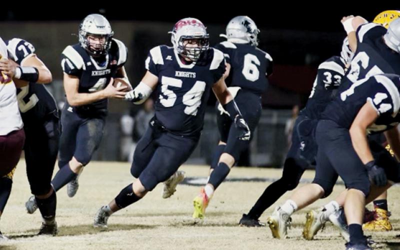 Senior lineman Carlos Lopez (54) makes sure junior running back Cuttler Adams has plenty of real estate ahead in Nov. 10’s game against Cherokee. Adams finished the game with 181 rushing yards – running his career total to 4,520 – and recorded three touchdowns.