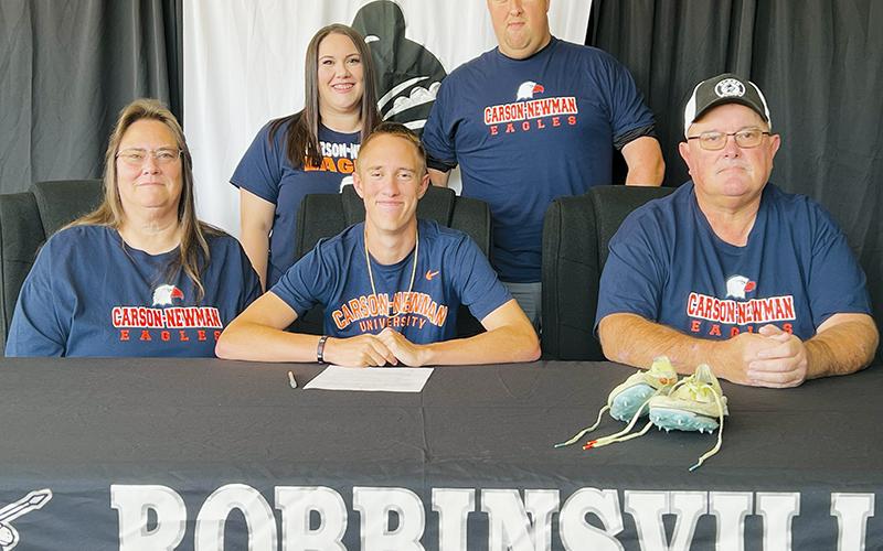 Robbinsville senior William Cable (seated, center) signed to run at Carson-Newman University on Monday. Sitting with Cable are parents Patsy (left) and Edward Cable. Standing in back are sister Jamie Carver and brother Patrick Cable. Photo by Kevin Hensley/sports@grahamstar.com