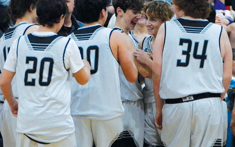 Eli Lambert (second from right) is greeted cheerfully by his teammates Nov. 17, moments after he drained a 3-pointer at the final buzzer to stamp Robbinsville Middle School’s 45-27 win over Hayesville. Photos by Kevin Hensley/sports@grahamstar.com
