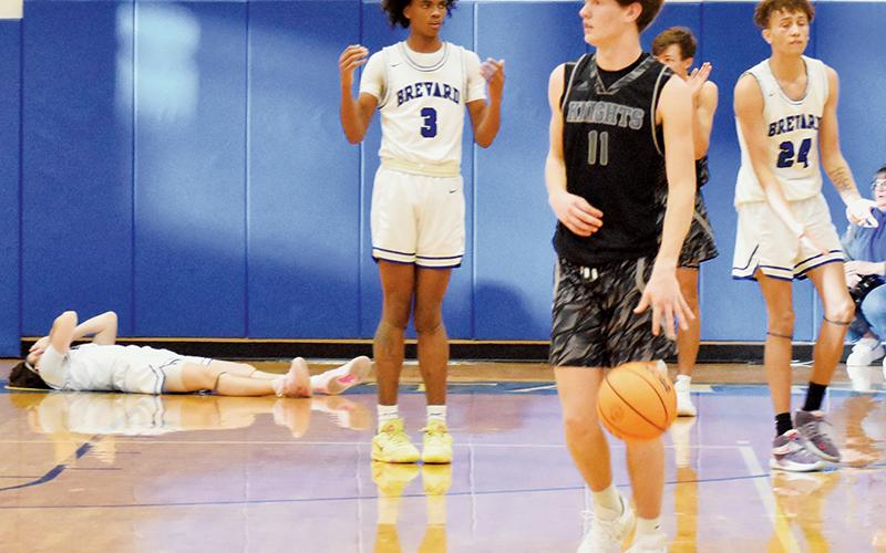 Black Knights junior Donovan Carpenter (11) was more than willing to pull away from Brevard’s Baker Buchanan (on the floor), Tre Crite (3) and Jaylen Brown (24) on Dec. 29, after Carpenter escaped with the game-clinching steal at the buzzer. Photo by Kevin Hensley/sports@grahamstar.com