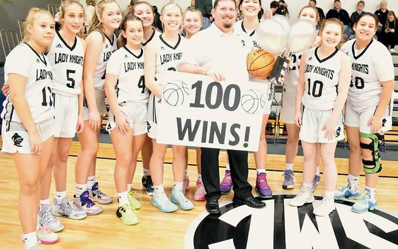 Prior to Tuesday’s home game against Blue Ridge School, the Robbinsville Lady Knights took a moment to recognize head coach Lucas Ford, who recorded his 100th win while guiding the program Jan. 3 at Hayesville. From left are Suri Watty, Anna Williams, Anna York, Desta Trammell, Katie-Lyn Gross, Kensley Phillips, Abby Wehr, Ford, Aubrie Wachacha, Liz Carpenter, Olivia Lewis and Fala Welch. Photos by Kevin Hensley/sports@grahamstar.com