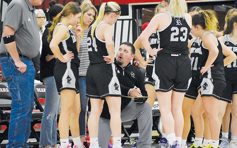 Lucas Ford (kneeling) draws up a play for the Lady Knights during a first-half timeout Monday at Pisgah. Robbinsville has advanced to at least the second round of the playoffs during four of Ford’s 5-plus years over the program.