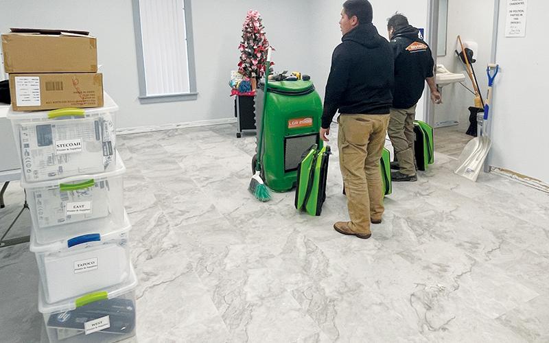 A clean-up crew from Servpro assesses the flooding that entered the Graham County Board of Elections’ new location in the community building early Friday morning.