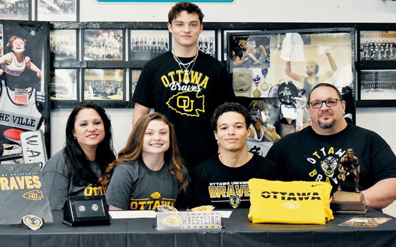 Fink and Nowell signed with family and friends alike on-hand to support their efforts. Here, Fink and  Nowell are flanked by mother Susan Crowe (seated, left); and father Todd Odom. Standing in back is Kyle Fink – Aynsley’s twin brother and himself a 3-time state champion.