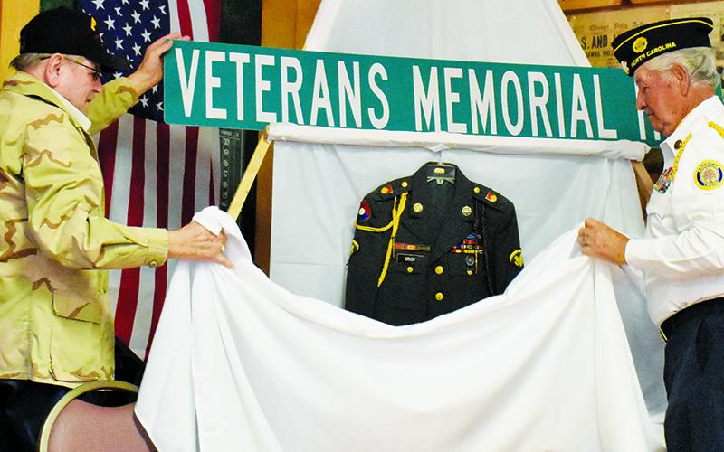 Vietnam War veteran Lamar Crisp (left) and American Legion Post 182 Commander Harold Phillips unveil the sign for Veterans Memorial Hill, which will share the same path as East Main Street in Robbinsville. Photos by Kevin Hensley/editor@grahamstar.com