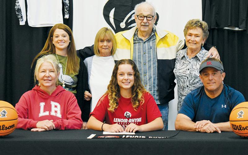 Desta Trammell signed to play basketball at Lenoir-Rhyne University on May 3. Seated with her are mother Kimm (left) and father Ritchie. Standing in back (from left) are cousin Shayla Bush,  grandmother Beverly Camden, grandfather Wesley Trammell and grandmother Lib Trammell. Photo by Kevin Hensley/sports@grahamstar.com