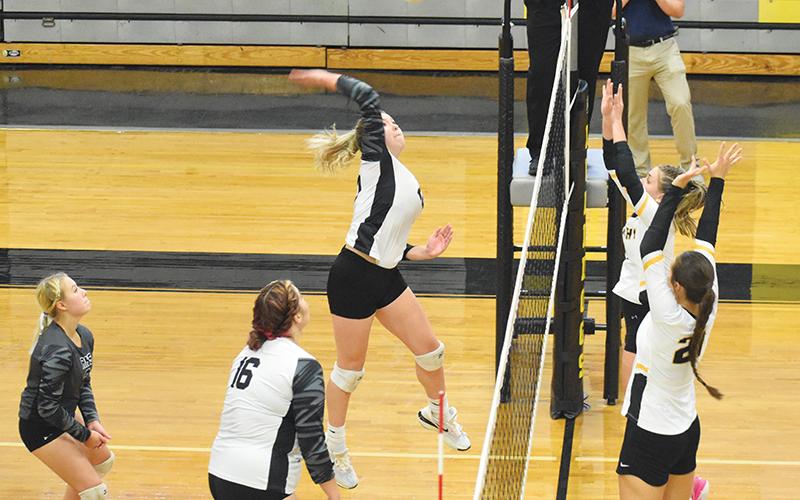 Liz Carpenter prepares to spike the ball Tuesday, as Murphy’s Cayla Greer and Lailee Holloway line up for a block attempt. Robbinsville won the first pairing between last year’s co-Smoky Mountain Conference champions in four sets. Photo by Kevin Hensley/sports@grahamstar.com
